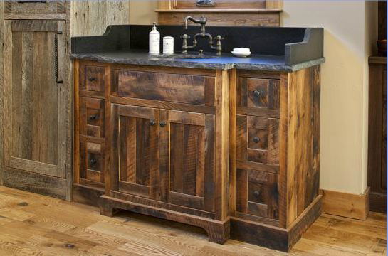Rustic wooden bathroom vanity with a black countertop and silver faucet.