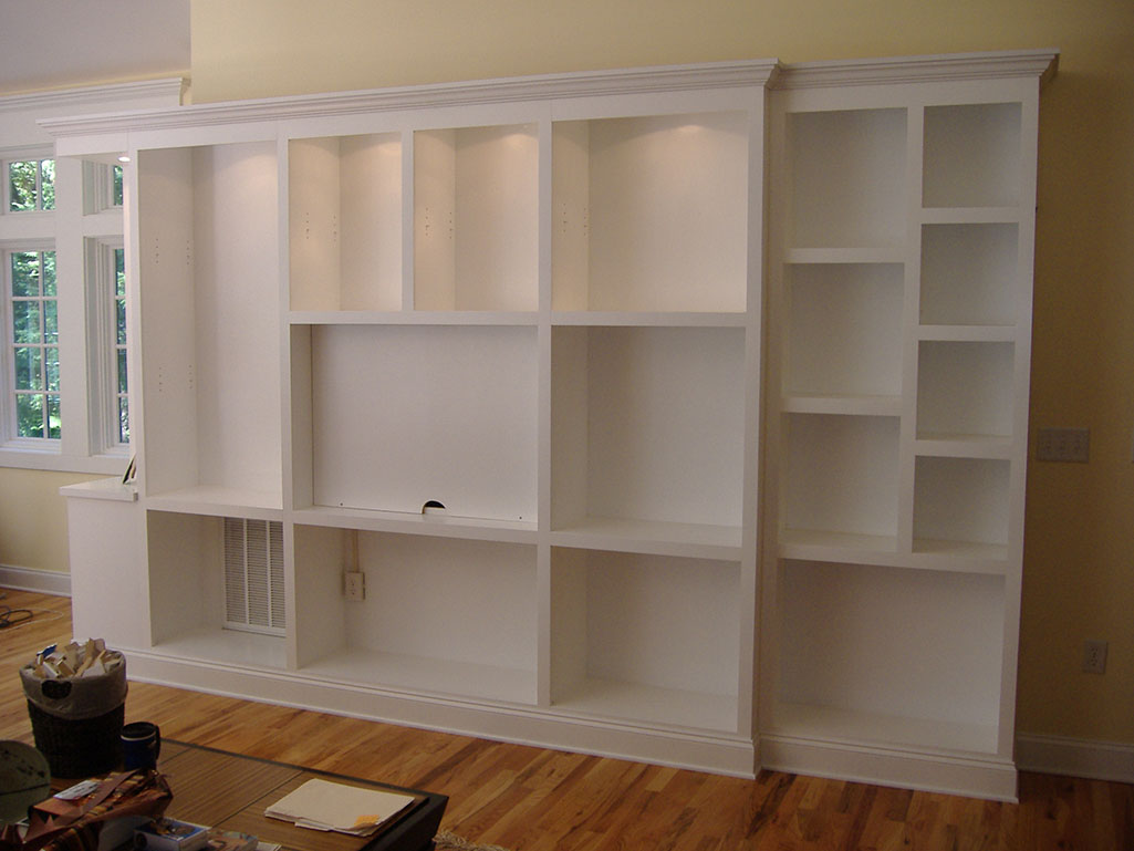 Large white built-in shelves and storage unit in an empty room.